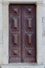 Old wooden door with wooden and metal ornaments in the historic part of Lisbon