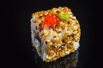 Sushi rolls Japanese cuisine in the restaurant. Sushi on a black background, caviar, closeup. Japanese restaurant menu