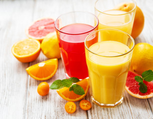 Glasses of juice and citrus fruits