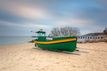 Baltic beach in Gdynia Orlowo with fishing boat at dawn, Poland