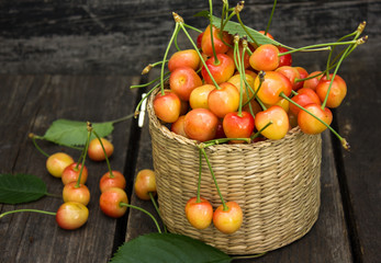 yellow cherry in sack basket o wooden table