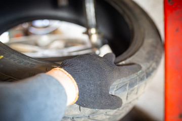 Fototapeta na wymiar Professional car mechanic replace tire on wheel in auto repair service