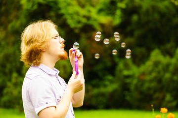 Man blowing soap bubbles outdoor