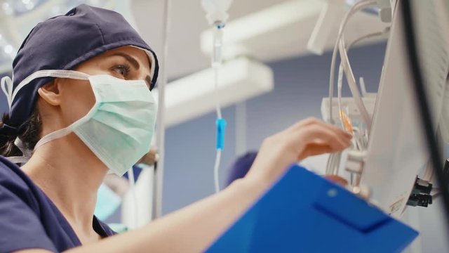 Female anesthesiologist writing down the updates  