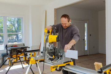 Carpenter using a circular saw to cut wood board