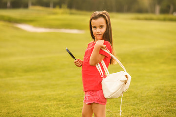 Pretty little girl with magnifying glass in summer park