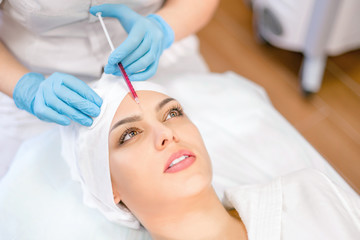 Cosmetology. A cosmetologist performs an injection procedure. Cosmetology clinic.