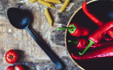 red pepper in a wooden bowl on an old wooden table