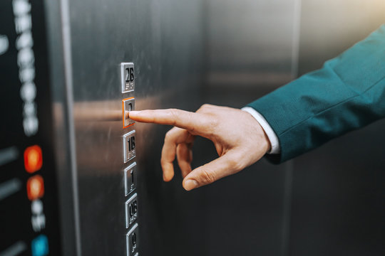 Close up of businessman pressing button on elevator.