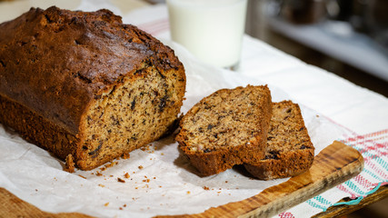Banana cake on a wooden background with a glass of milk