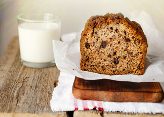Banana cake on a wooden background with a glass of milk