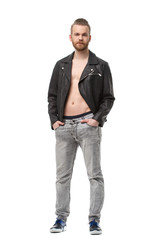 Charismatic bearded man in a unbuttoned leather jacket on his naked body stands in full growth isolated on white background.