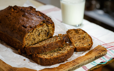 Banana cake on a wooden background with a glass of milk