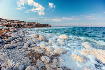 .incredibly beautiful seaside of the dead sea with blue water and white crystals of salt near.selective focus
