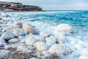.incredibly beautiful seaside of the dead sea with blue water and white crystals of salt...