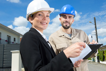 construction worker with female engineer studying documents