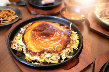 Okonomiyaki in teppanyaki pan at restaurant.  Japan food concept