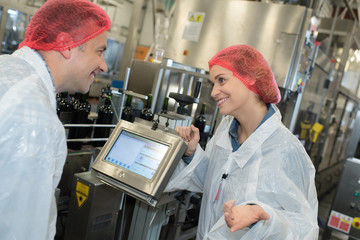 man and woman wearing hair nets making notes on clipboard