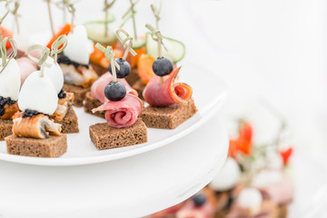 Buffet table. Assortment of canapes. Banquet service in restaurant. Catering food, snacks on white plate