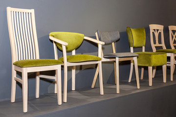 wooden chairs with green upholstered near grey wall