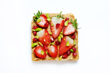 Healthy vegan breakfast concept. No bake no crunch peanut butter sandwich with strawberry, perfectly toasted bread, clean eating food. White table background. Top view, close up, copy space, flat lay.