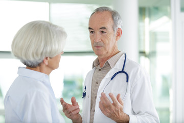 doctor talking to senior female patient in the corridor