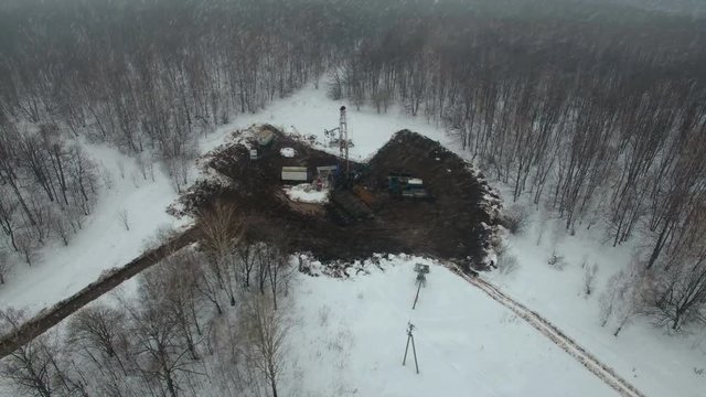 Drilling a deep well with a drilling rig in an oil and gas field in winter forest. The field is located in Kamchatka, Tundra, Yamal, North, West, Siberia, fog, aerial, snowfall, flakes, snowstorm