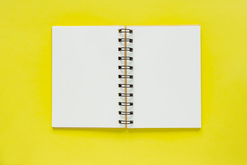 Clean spiral note book for notes on yellow background. Minimal business flat lay mock up