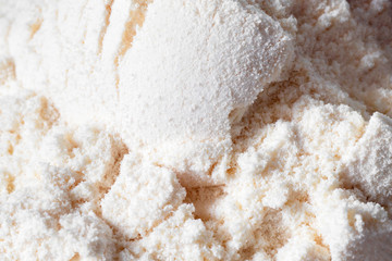 Heap of yellow banana protein powder on dark background. Top view