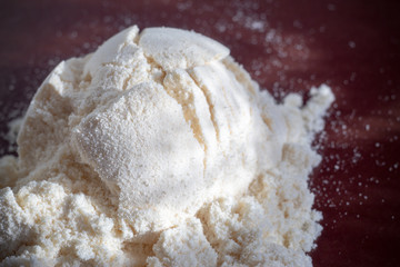 Heap of yellow banana protein powder on dark background. Top view