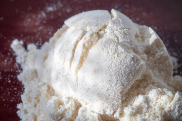 Heap of yellow banana protein powder on broun background. Top view