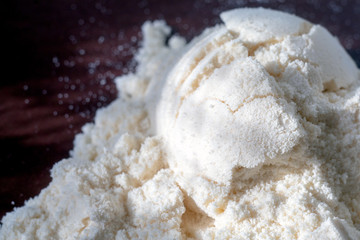 Heap of yellow banana protein powder on broun background. Top view