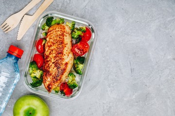 Grilled chicken meal prep containers with rice, broccoli and tomatoes.
