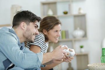 couple leaning to one side playing computer game