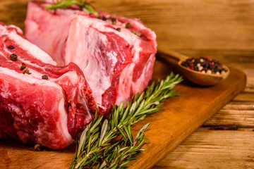 Raw pork ribs with spices and rosemary on a cutting board