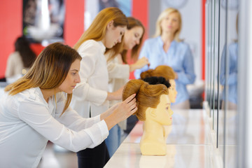 young hairdresser training on mannequin