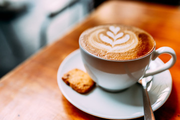 cup of coffee with whipped cream on wooden background