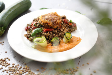 Vegetarian cooking. Colorful vegetable meatless dish. Boiled lentils with carrot puree and grilled zucchini.