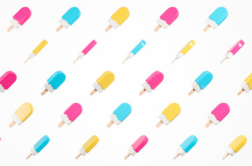 Pattern made of flying glossy  yellow, pink and blue  lolly ice cream isolated  on the white background.