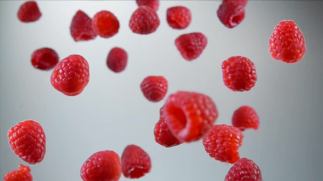 Ripe raspberry fly and rotates in the air on a white background