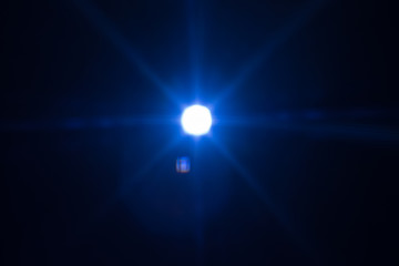 Distant cold blue star glowing. Lens flare effect. Universe darkness