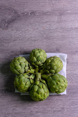 Obraz premium karczochy na szarym tle. świeży organiczny kwiat karczocha