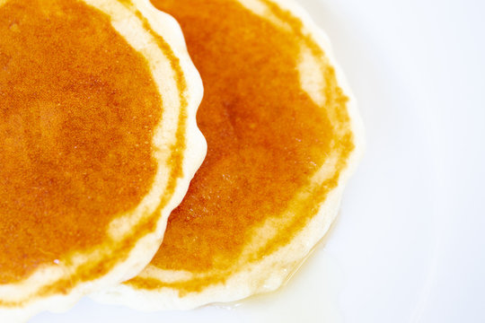 Image of pancakes dripped with wild honey on a dish close up.