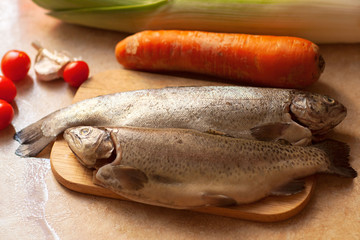 Cooking fish dinner. Flat-lay of raw  sea bass with  vegetables over rustic background, top view.  Healthy, clean eating, dieting food concept