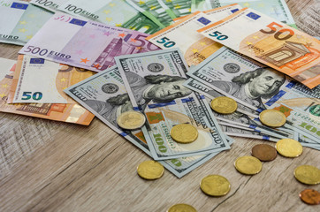 Euro, coins, dollars on a wooden background close-up