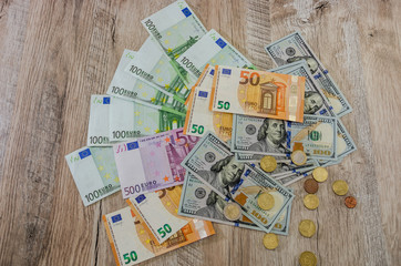 Euro, dollars, cents spread out on a wooden background