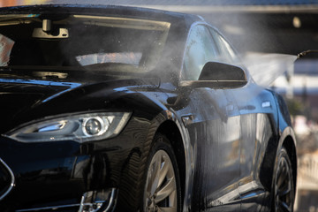 Washing car in a manual carwash (color toned image)