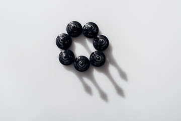 top view of black chess figures in circle with shadows on white background