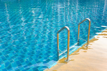 Swimming pool with grab bars ladder and stairs.