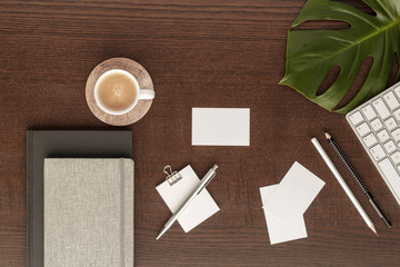 workspace  pen  pencil business card  notes notepad  coffee cub   paperclip  copy space  leaf monstera  top view with copy space for your text. flat lay. 